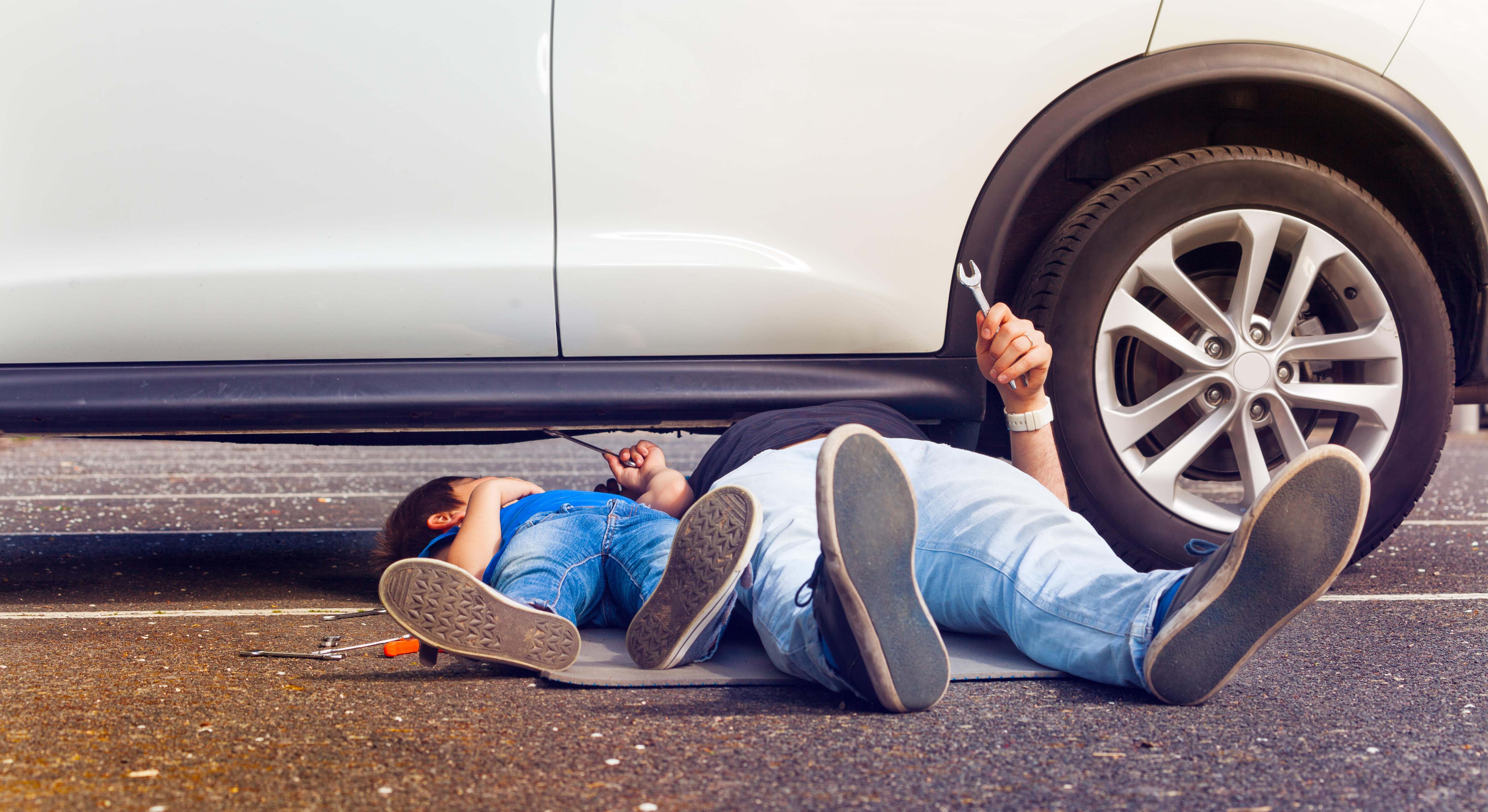 Padre e hijo revisando coche