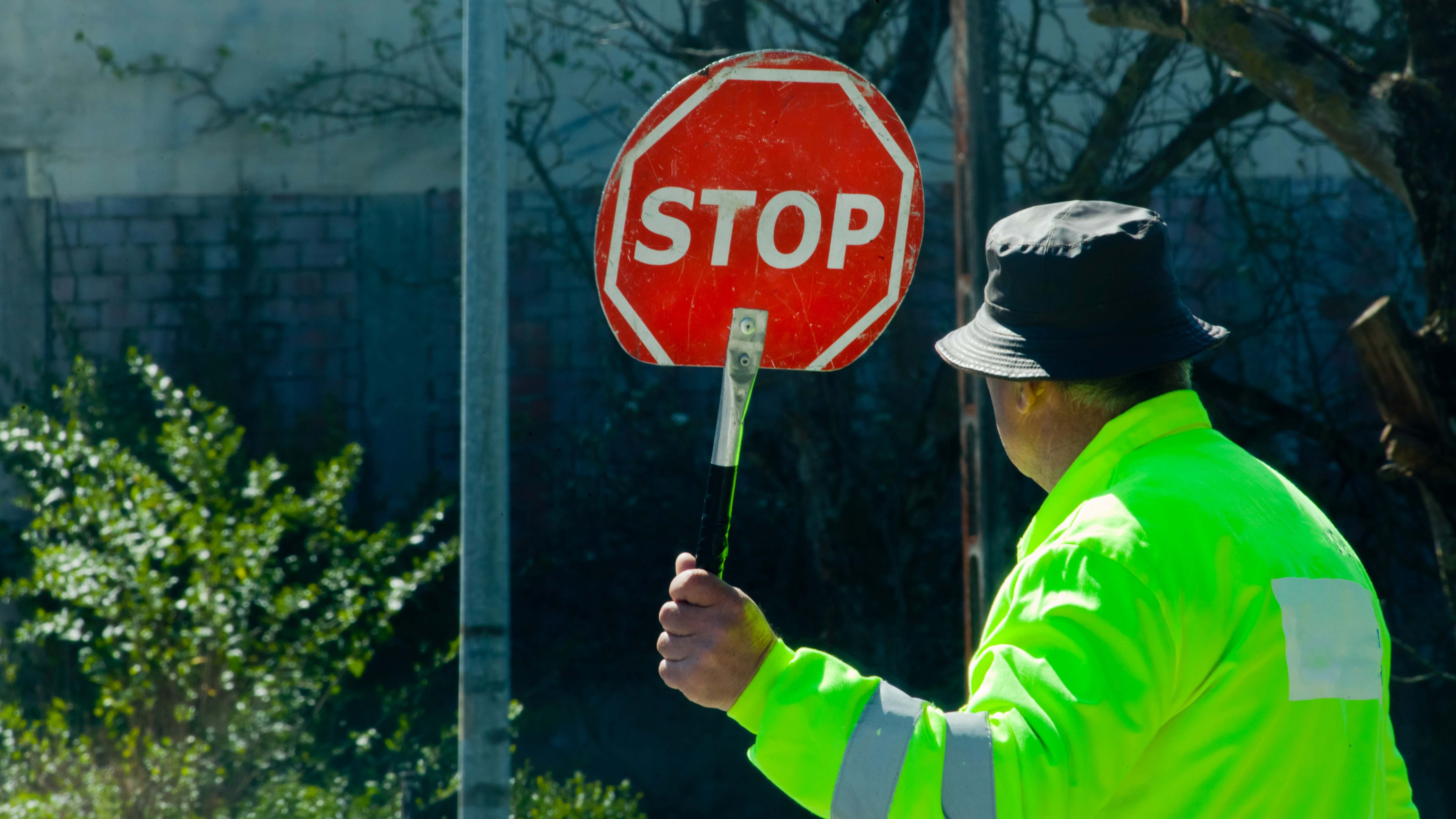 Trabajador mayor sujetando una señal de stop
