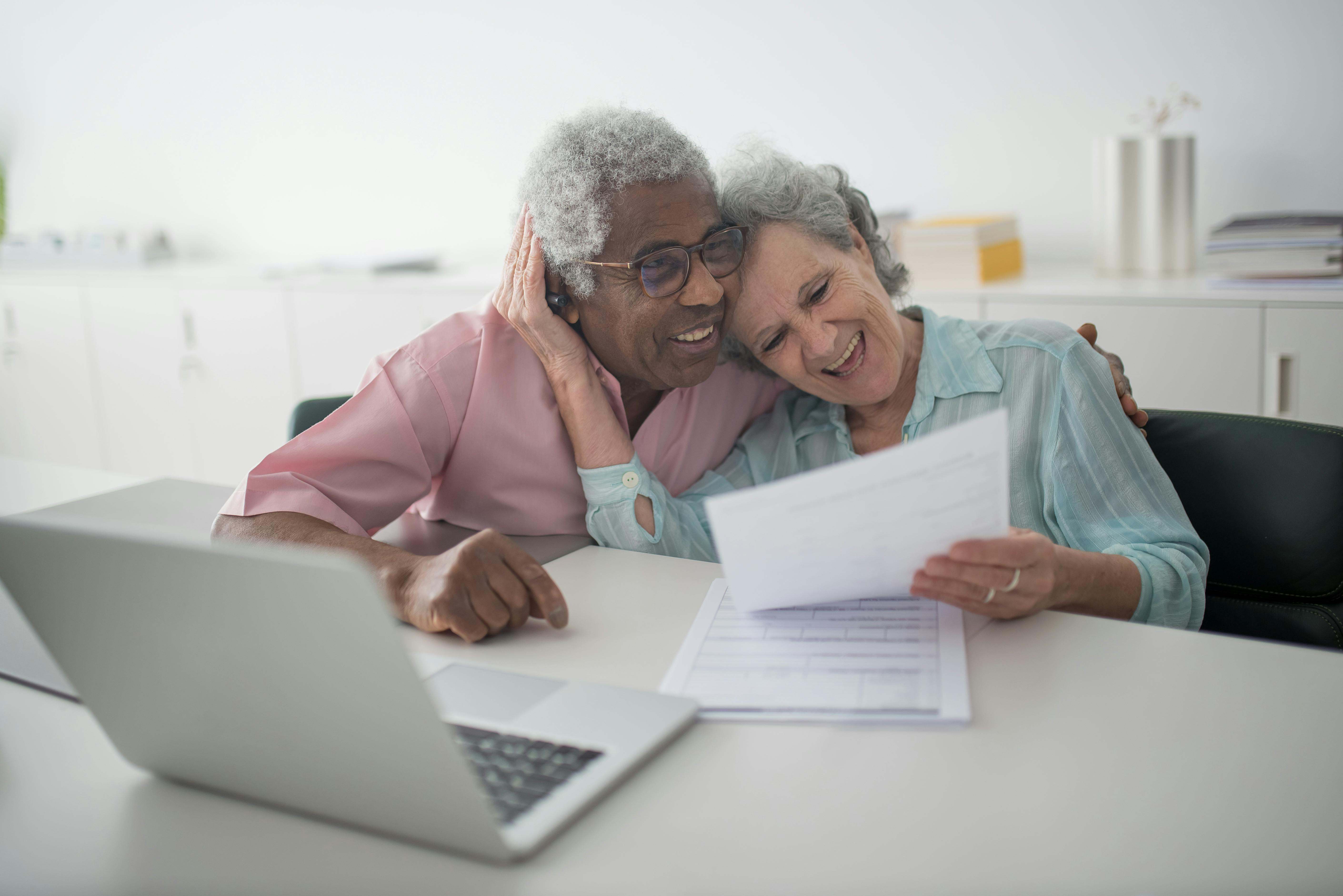 Dos personas de avanzada edad mirando una cosa en el ordenador