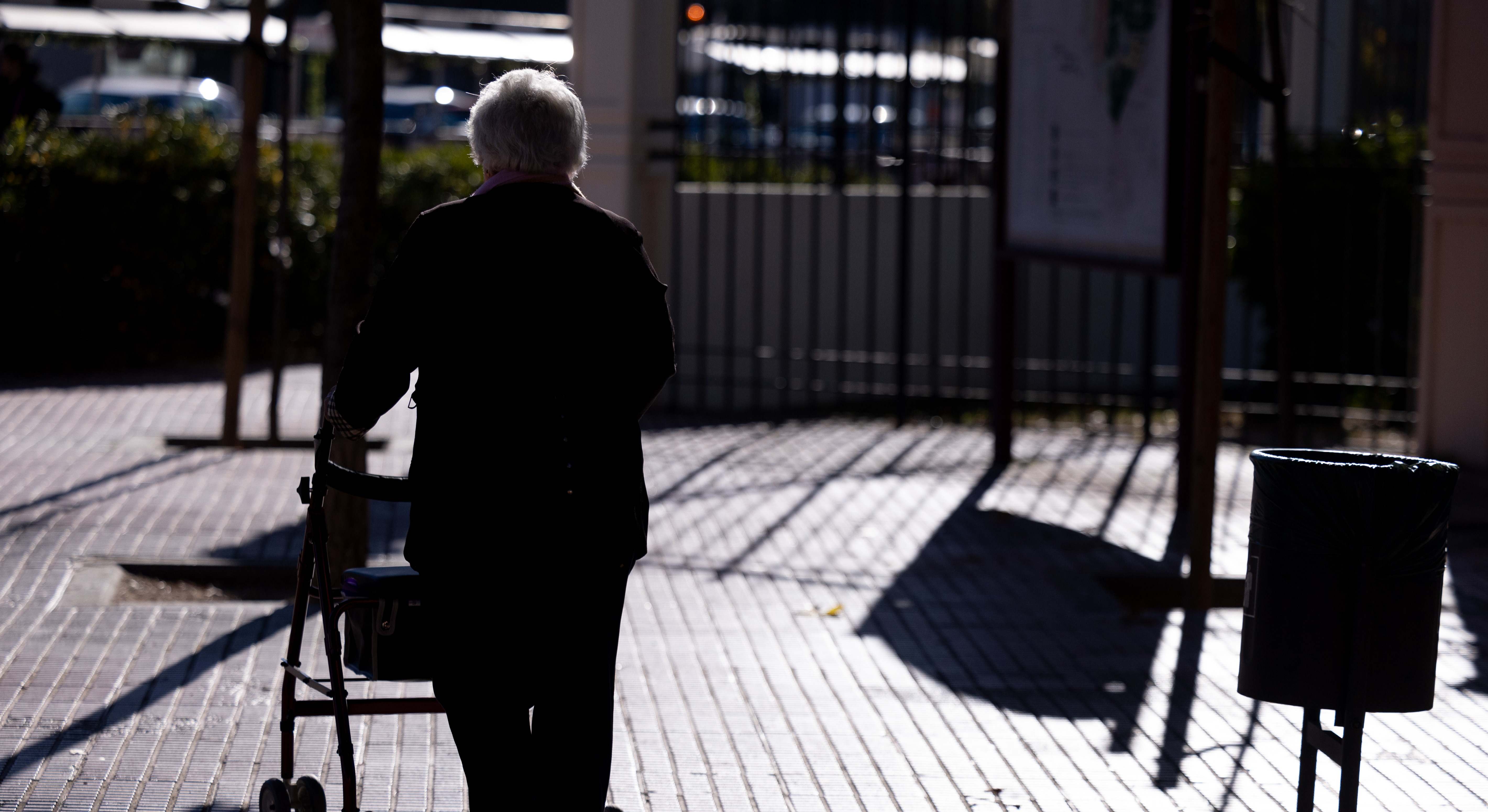 Una mujer jubilada camina por la calle.