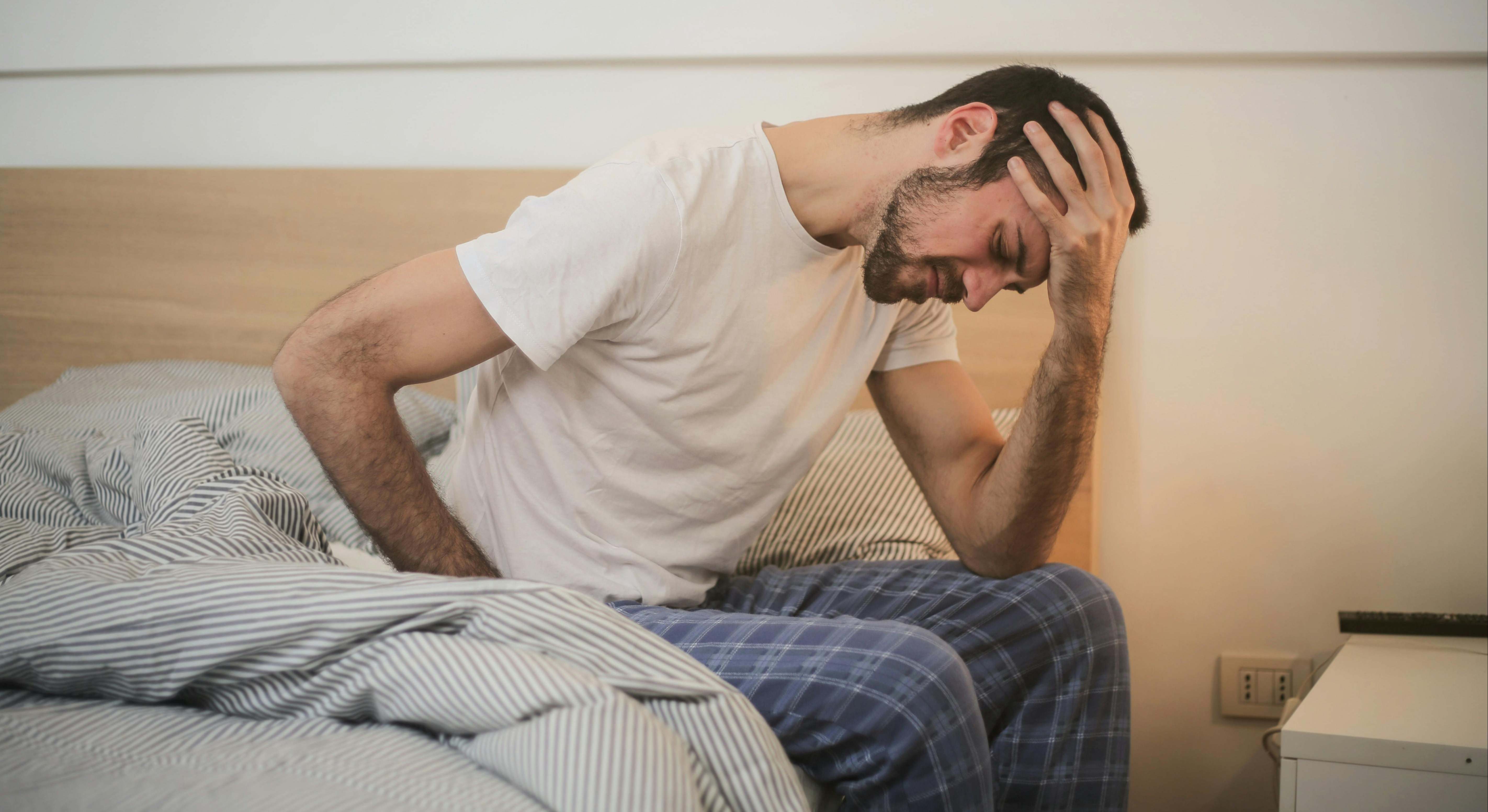Un hombre tiene una resaca muy grande tras haber tomado alcohol el día anterior