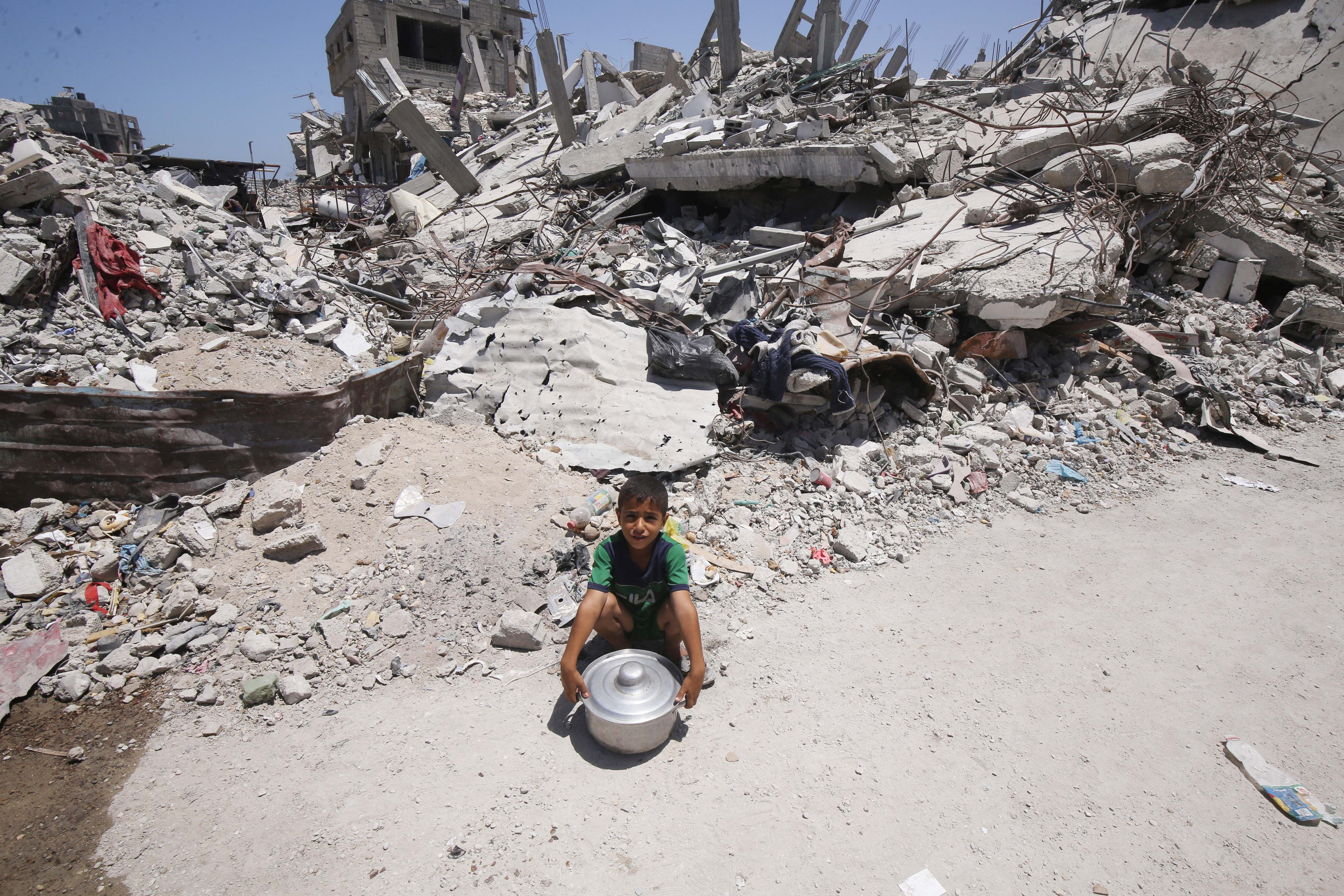 Un niño gazatí frente a una pila de escombros tras un bombardeo israelí.