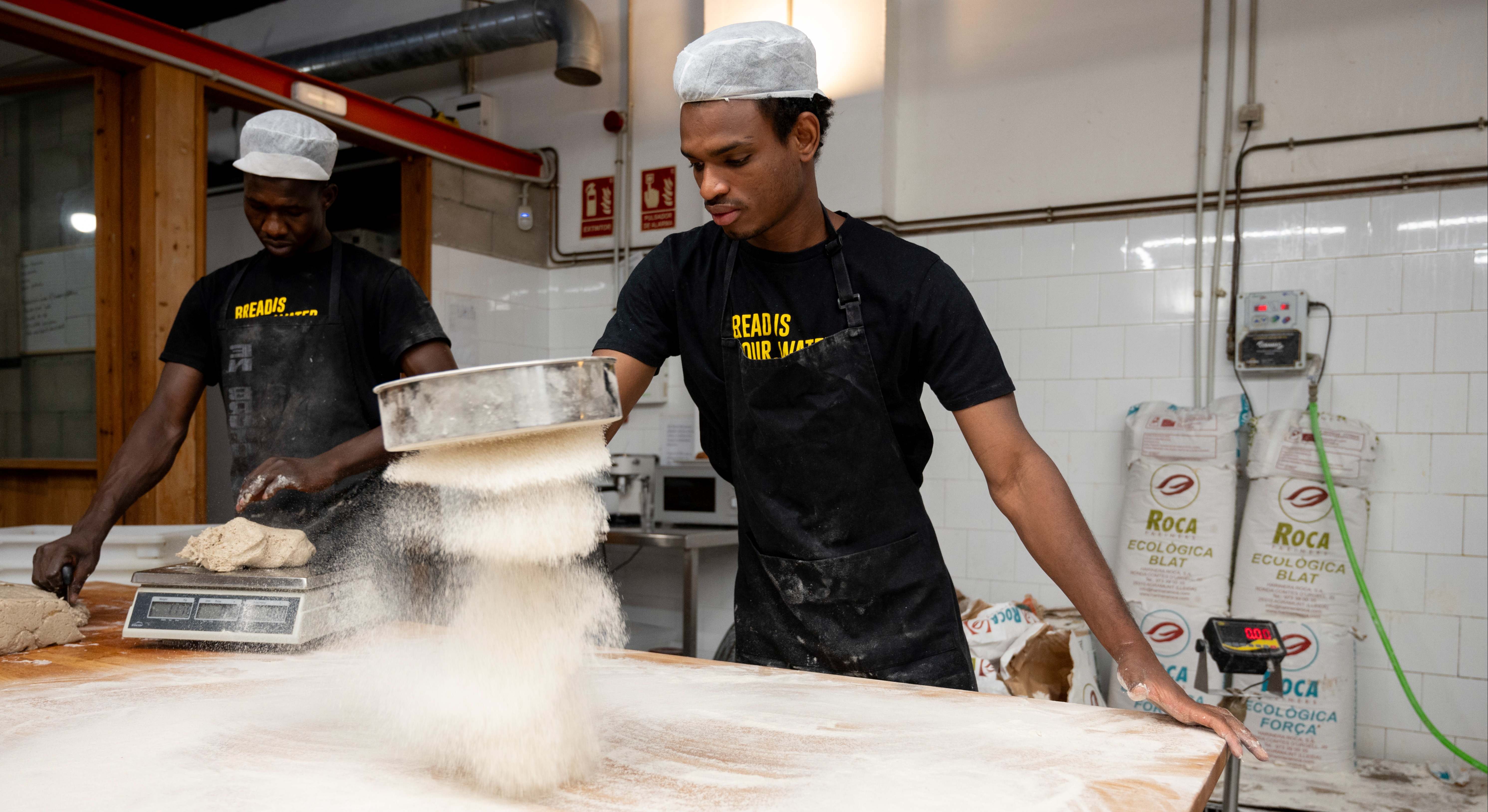 Djogo (derecha) encontró trabajo en el obrador de la panadería madrileña Panic, que colabora con el programa Incorpora. 