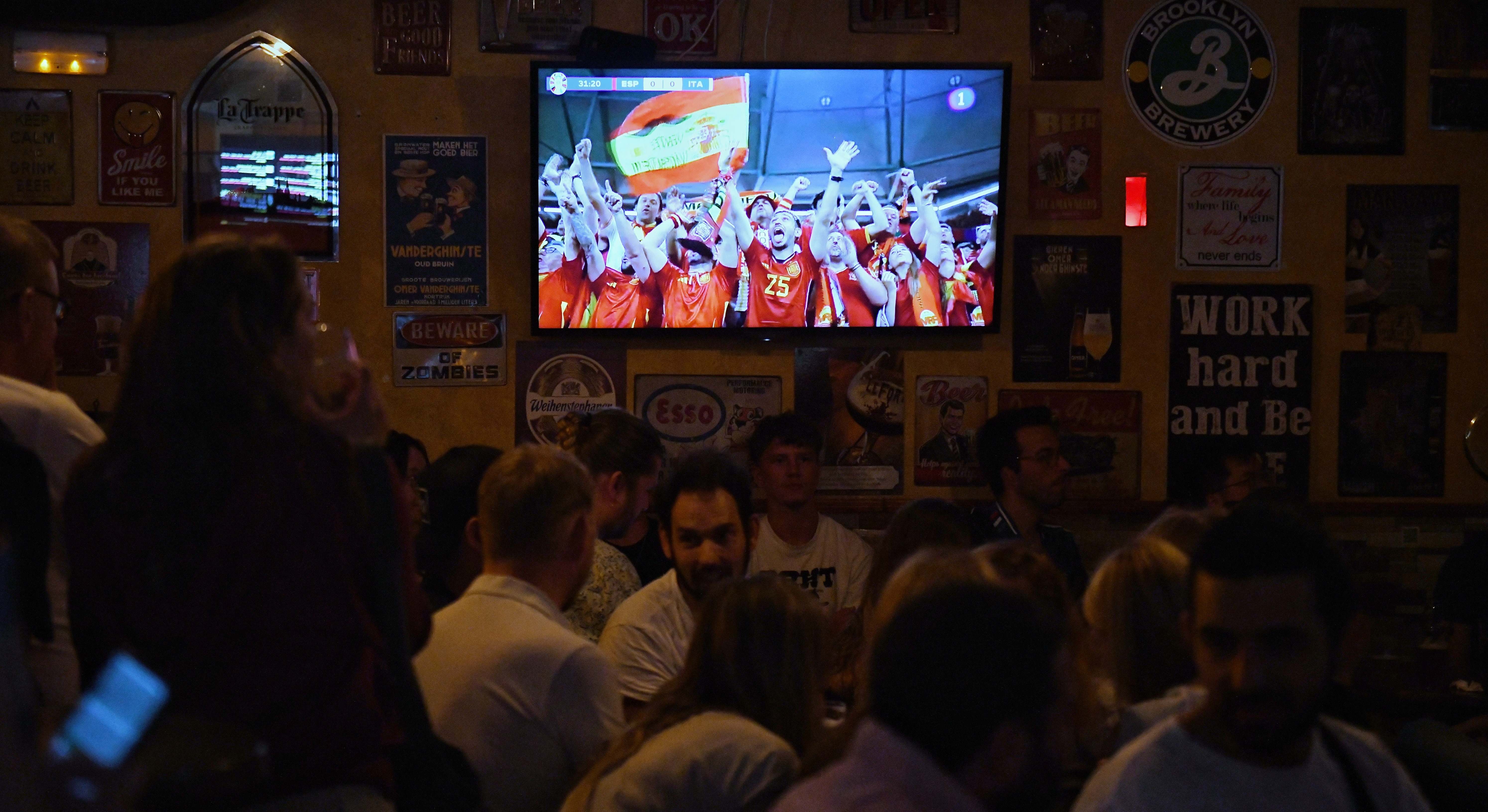 Varios aficionados ven por televisión el partido entre España e Italia de la Eurocopa 2024,