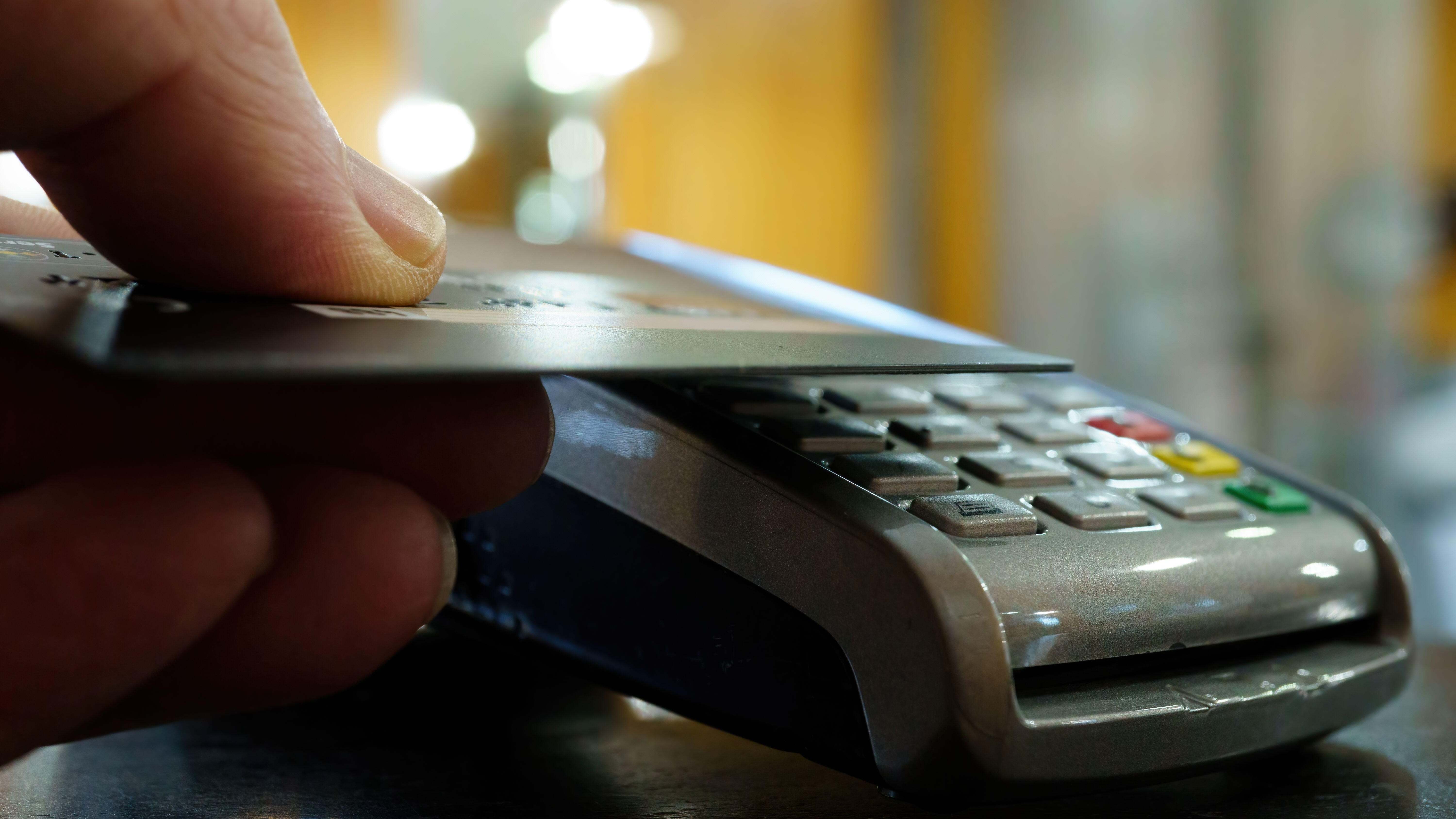 Una persona paga con tarjeta a través de un datáfono