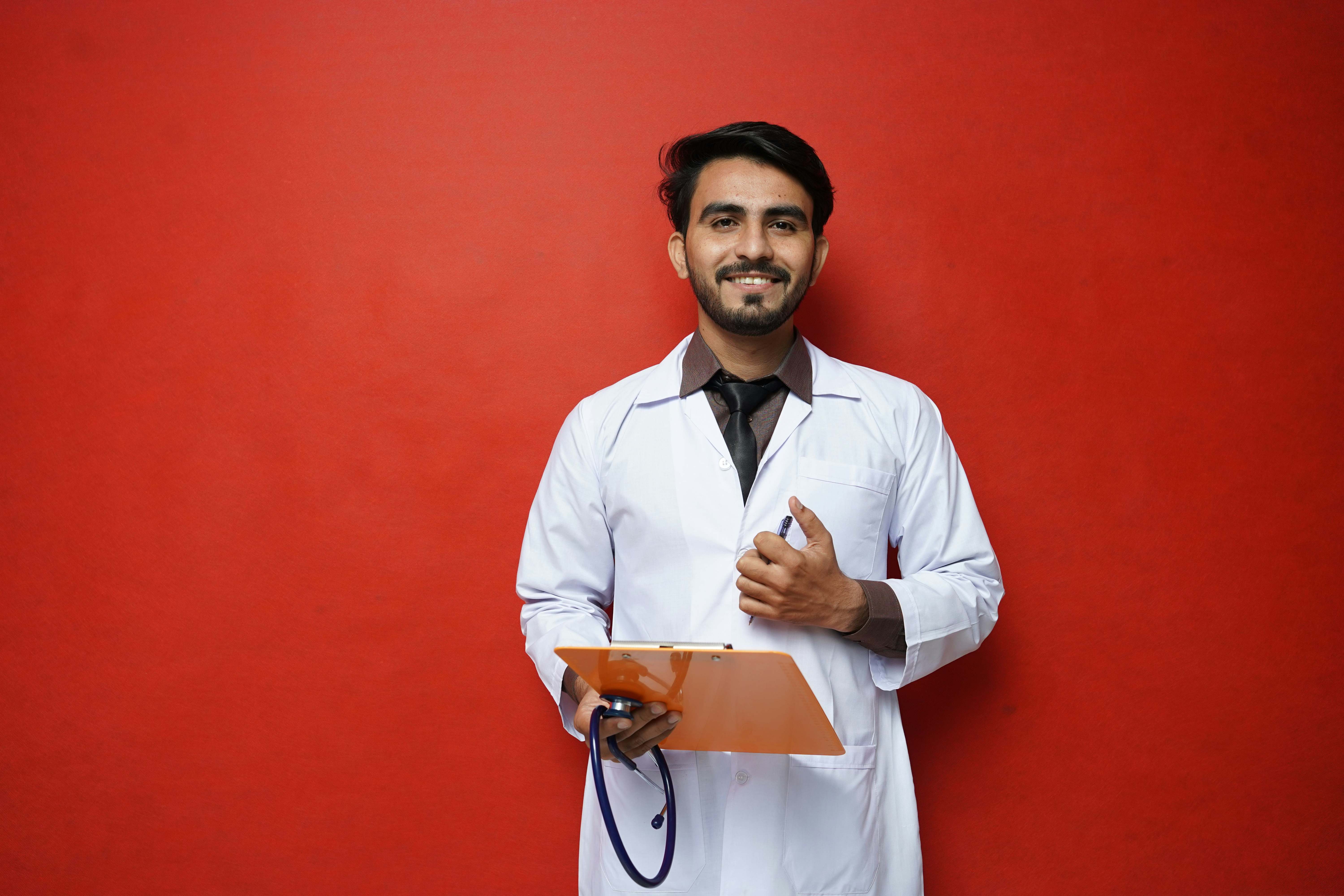 Un cardiólogo, con sus herramientas para trabajar, sonríe ante la cámara