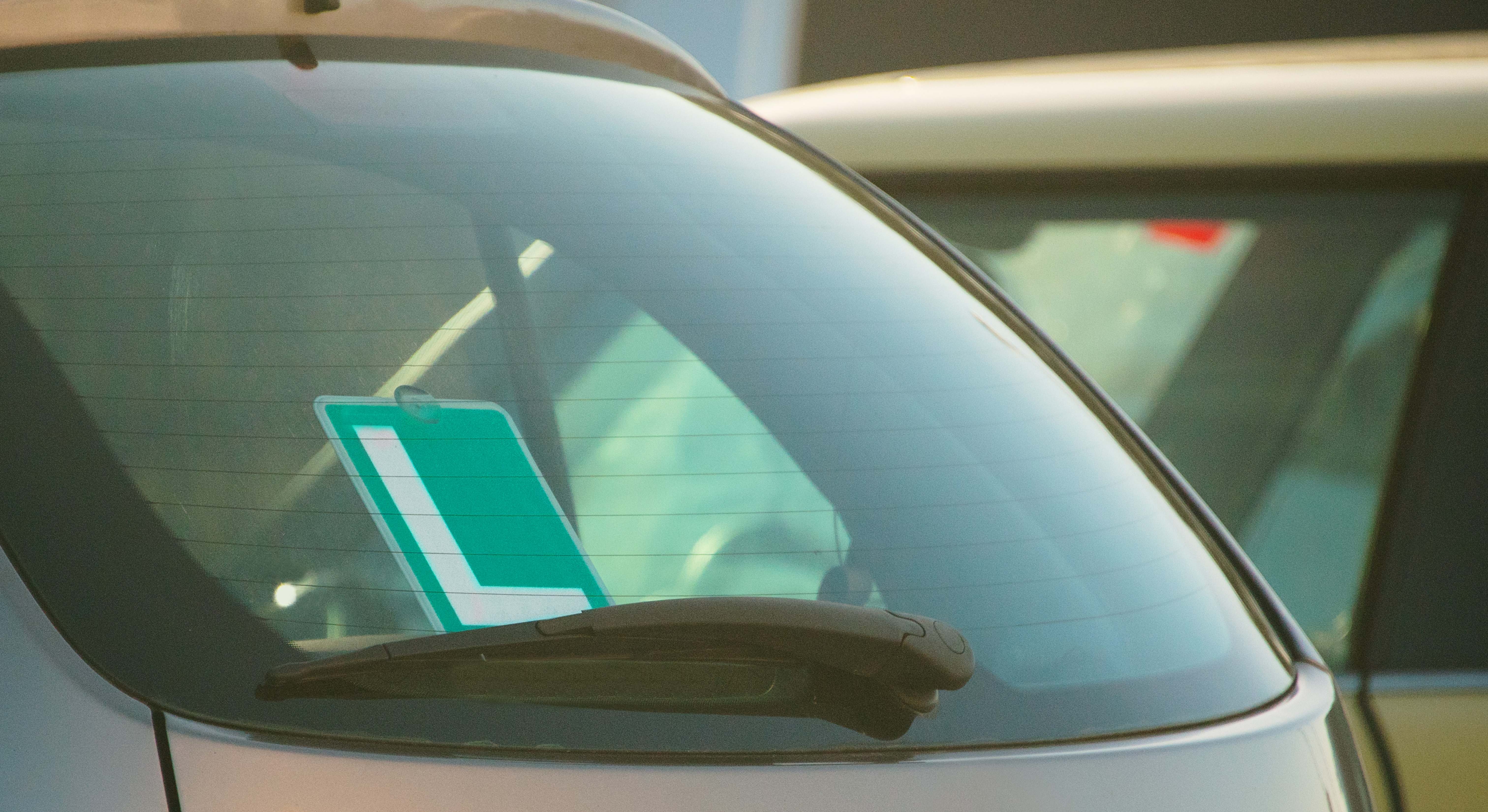 Una señal de conductor novel en la luna trasera de un coche