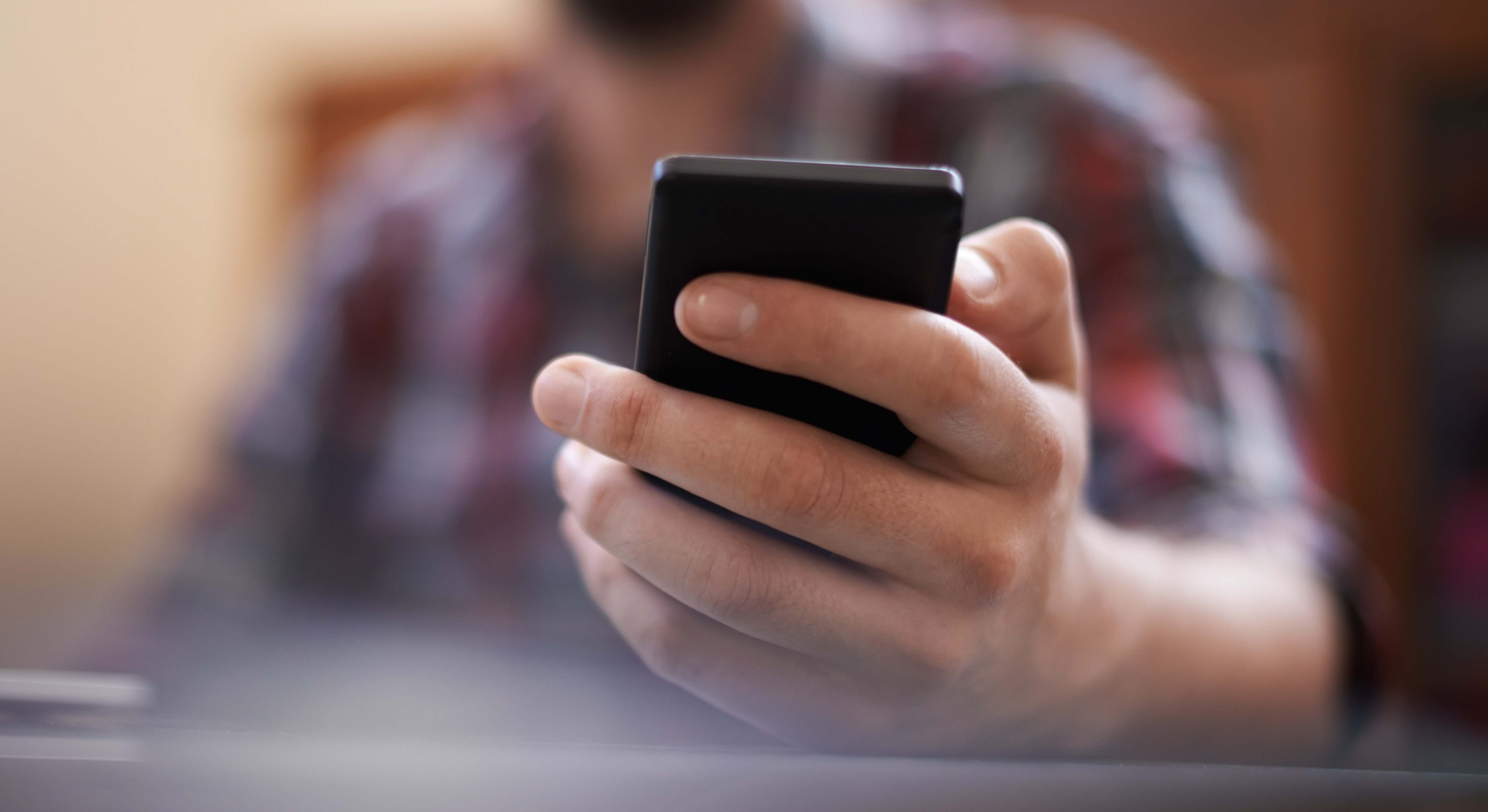 Una persona mira un teléfono móvil
