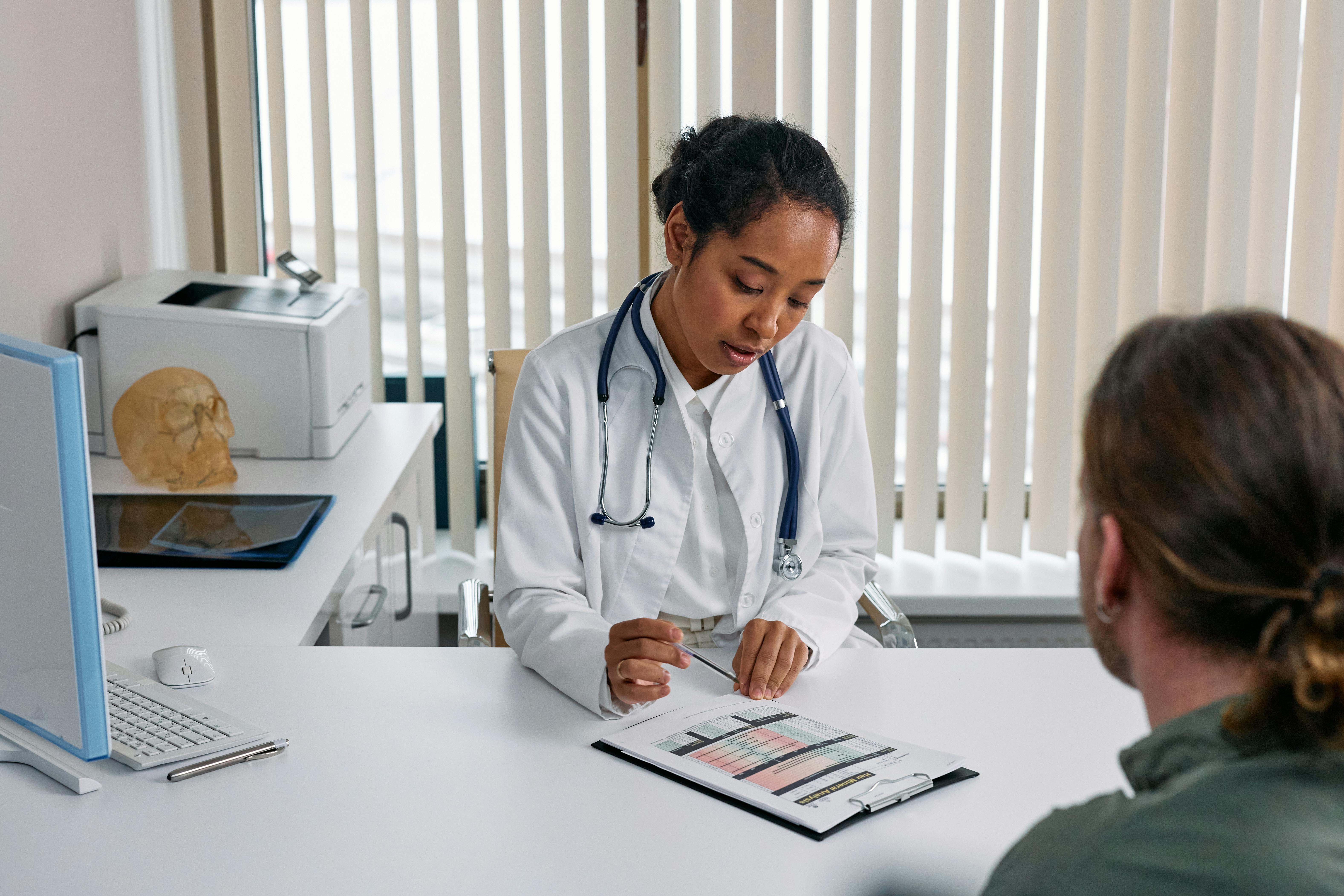 Una médica atiende a un paciente en una consulta