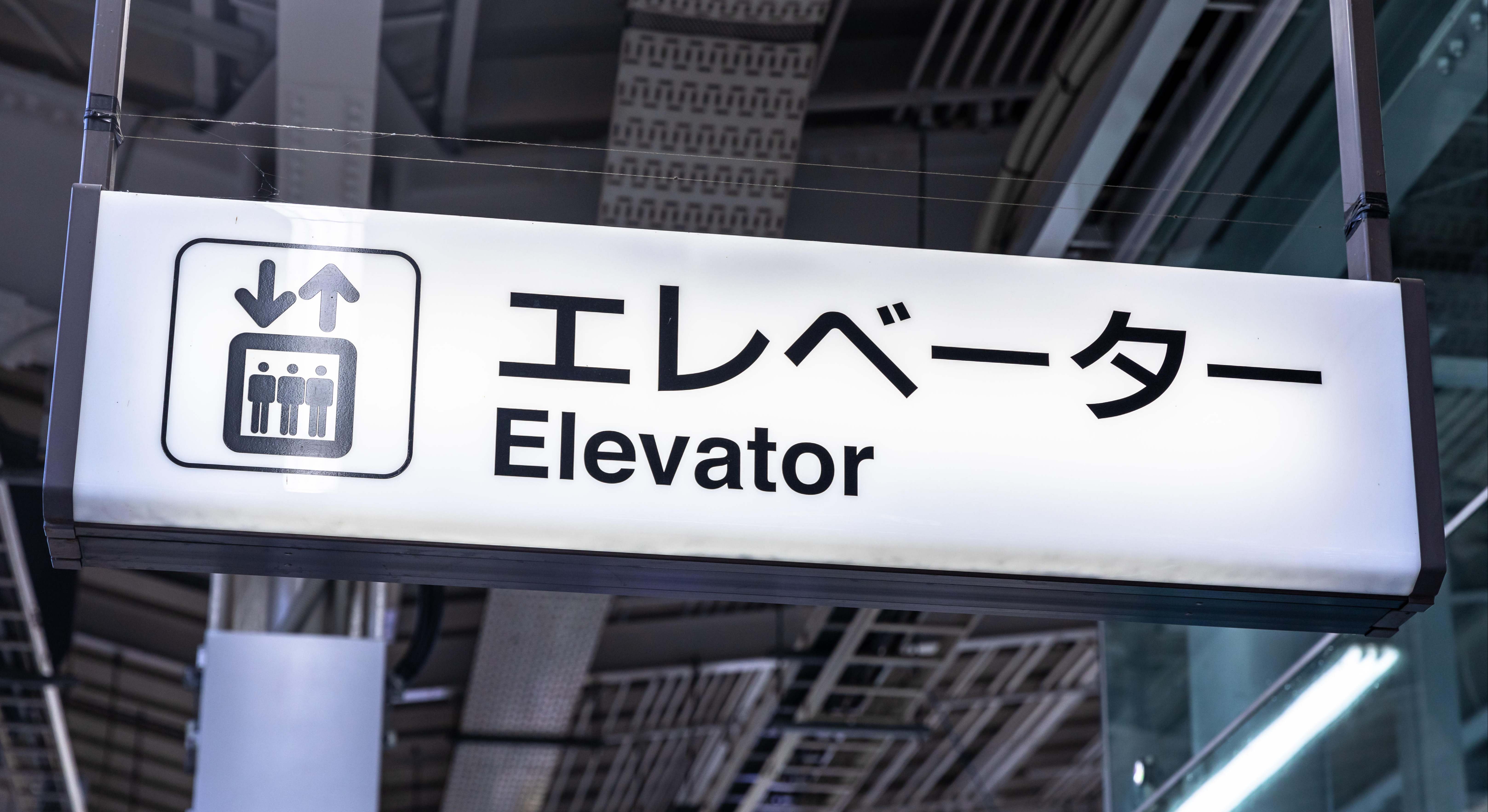 Letrero de un ascensor en inglés y en japonés