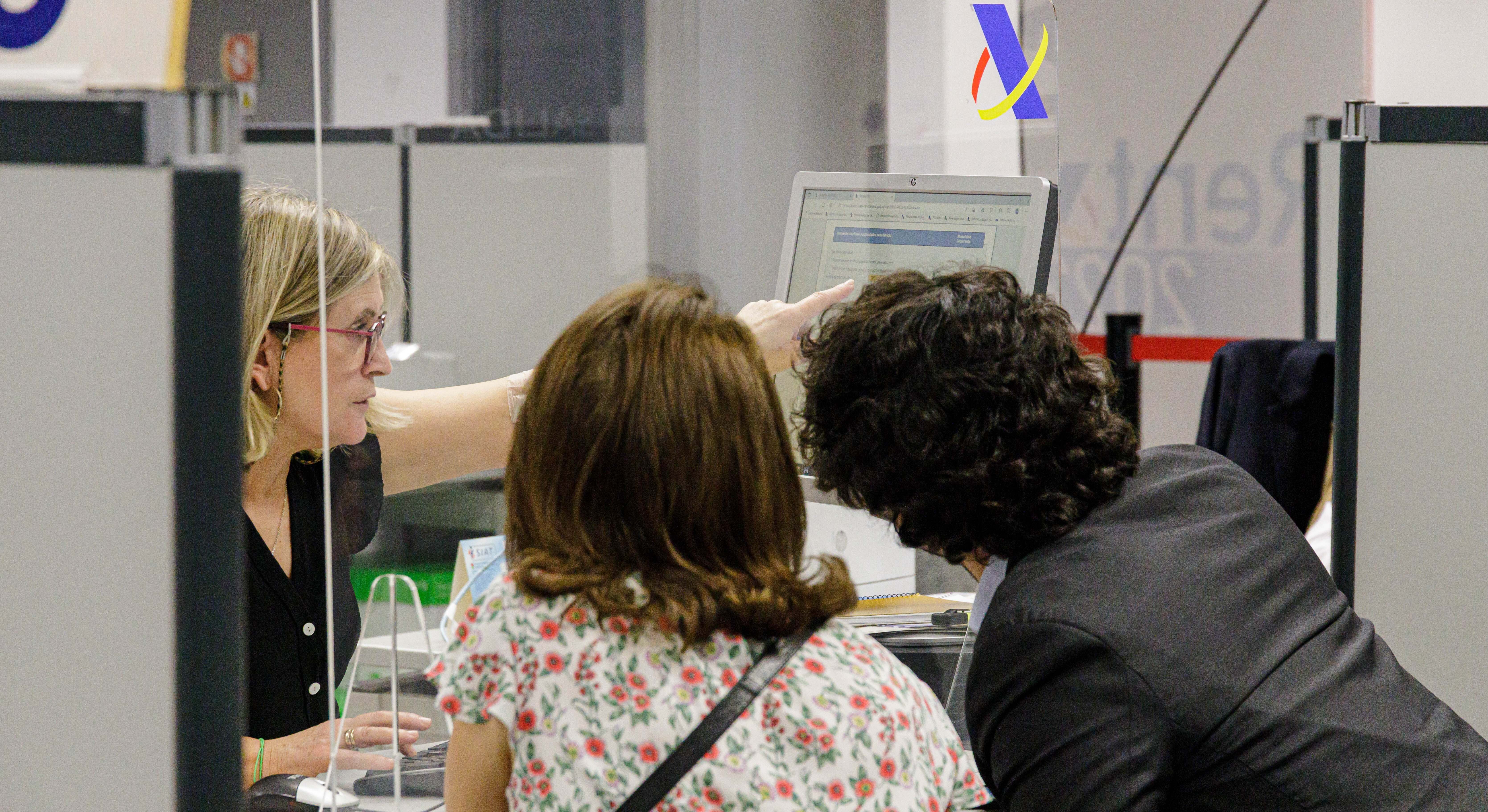 Dos personas en una oficina de la Agencia Tributaria