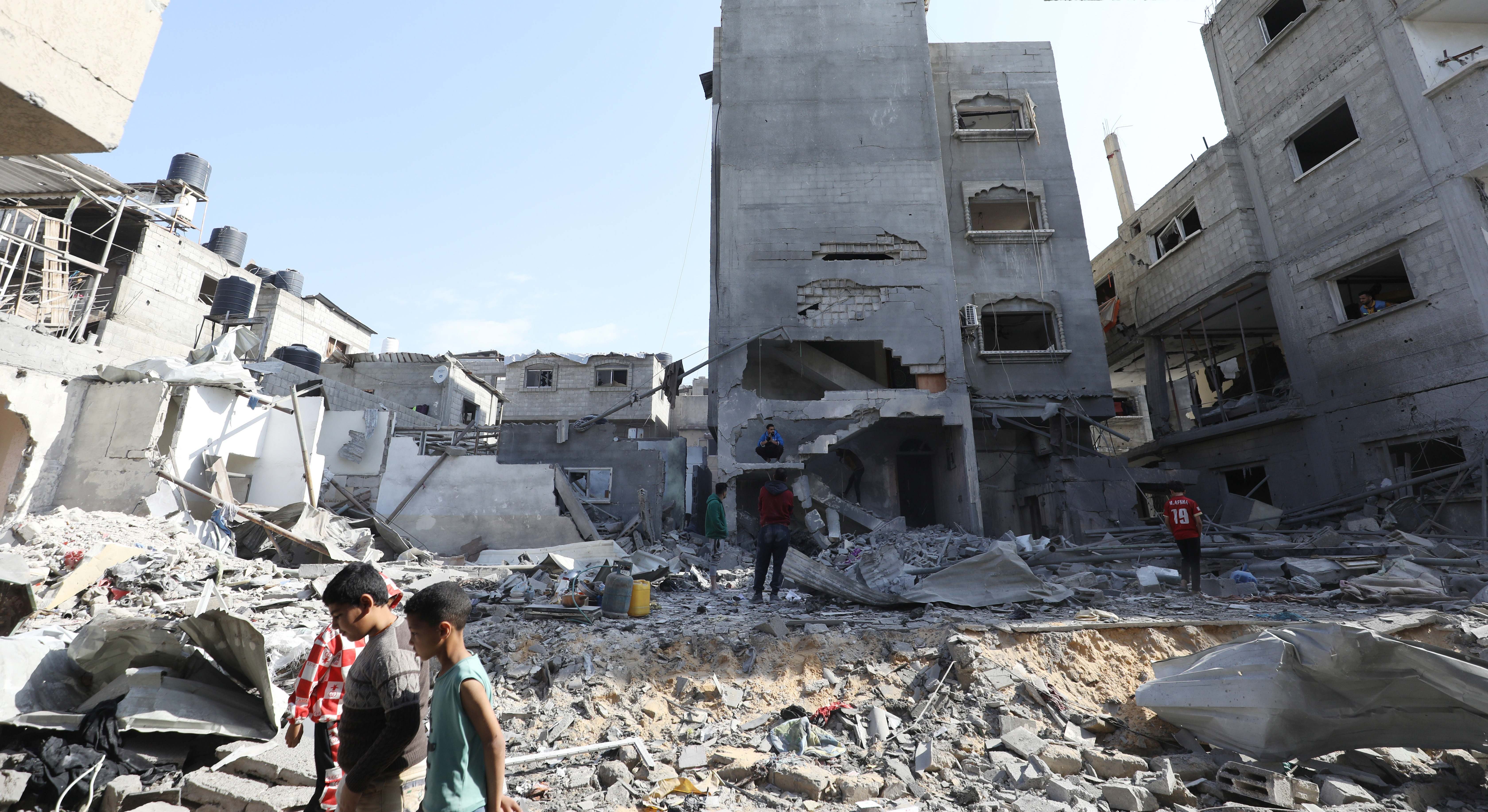 Niños palestinos caminan sobre las ruinas de Gaza