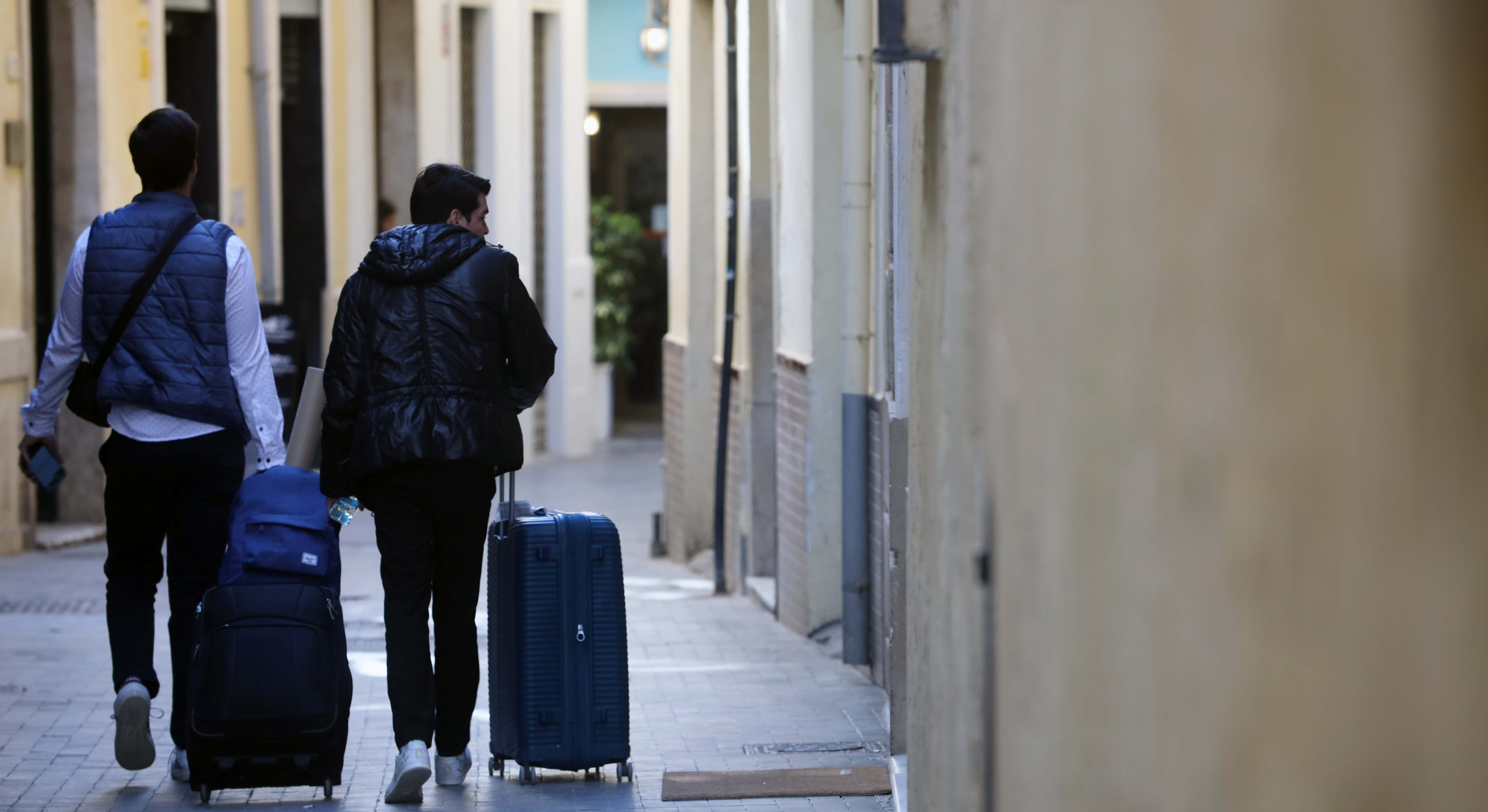 Dos personas con maletas en una calle