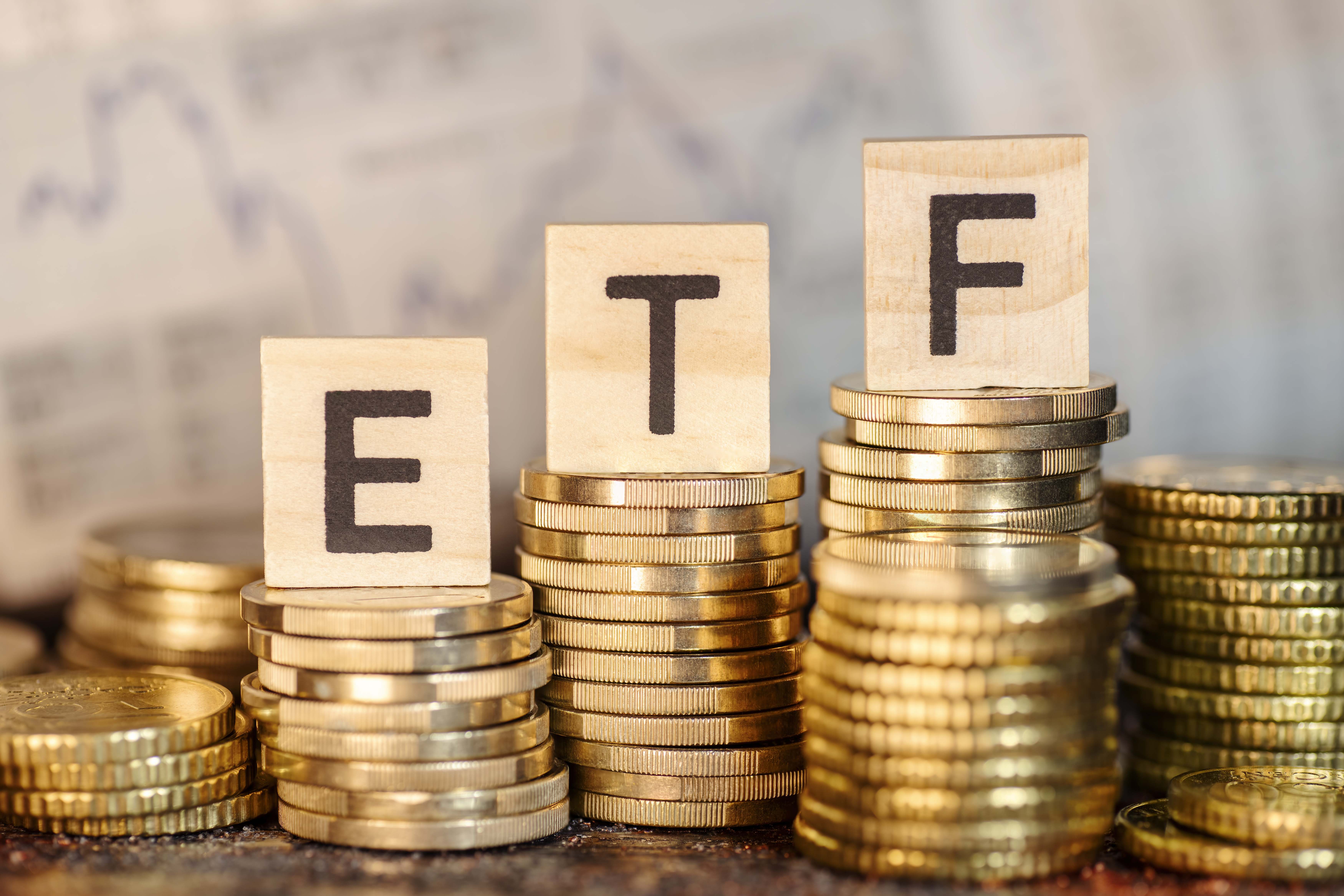 Siglas ETF sobre montones de monedas cada una