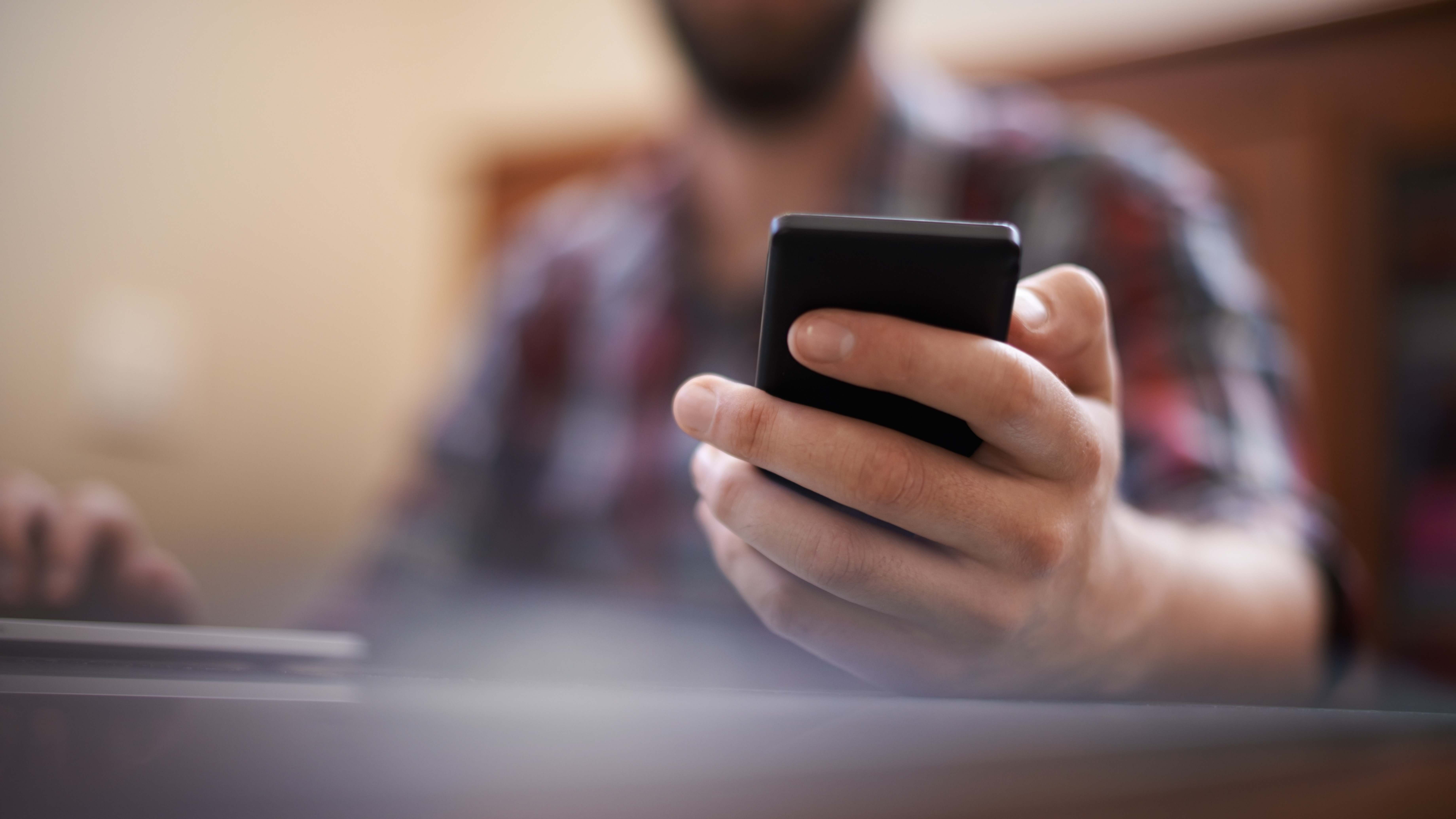 Una persona con teléfono móvil en la mano