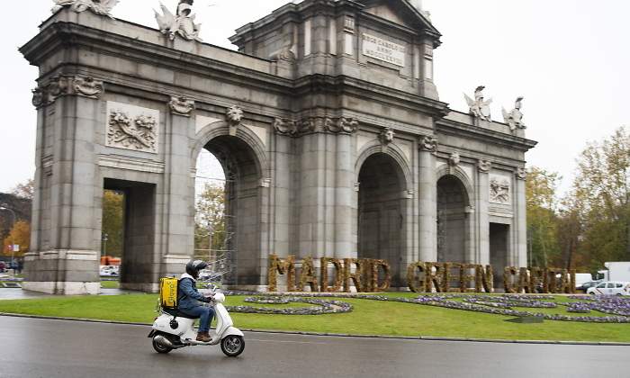 Un repartidor de Glovo pasa por la Puerta de Alcal
