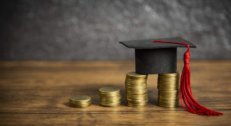 Un birrete sobre unas monedas transmite la idea de beca universitaria