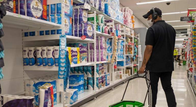 Un hombre con mascarilla hace la compra en un supermercado