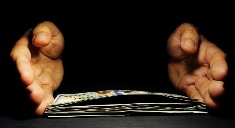 manos-dinero-oscuro-dreamstime.jpg