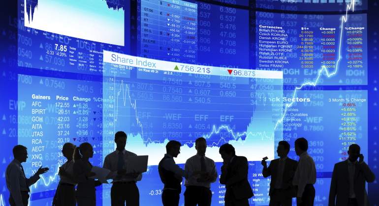 Varias personas que parecen inversores hablan sobre un fondo con grficas
