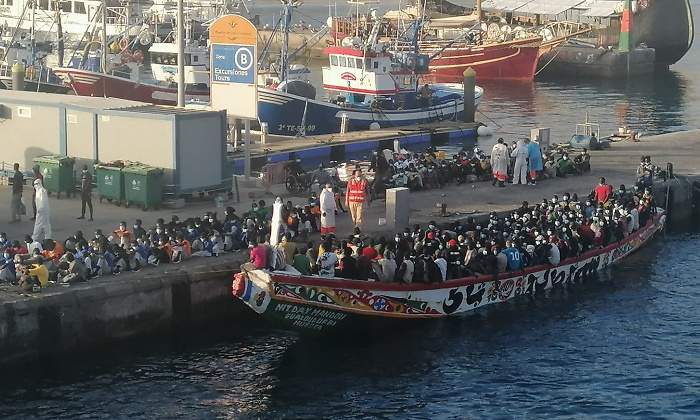 Un barco con inmigrantes llega a puerto donde esperan ms migrantes