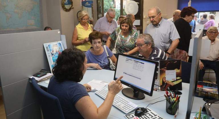Personas mayores son atendidas en una agencia de viajes