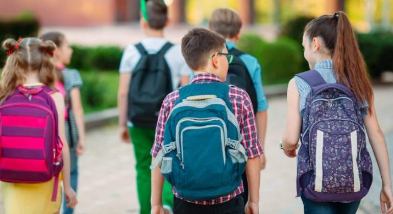 Nios con mochilas que van al colegio