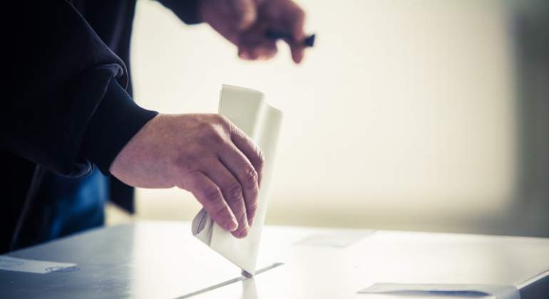Alguien deposita un voto en una urna electoral