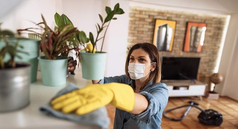 Un-mujer-con-mascarilla-limpiando-su-casa-iStock.jpg