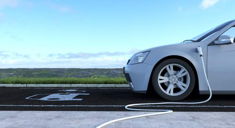 Un coche elctrico se recarga con un jardn en el horizonte