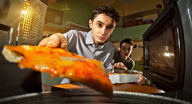 Una-persona-metiendo-un-trozo-de-comida--en-el-microondas-iStock.jpg