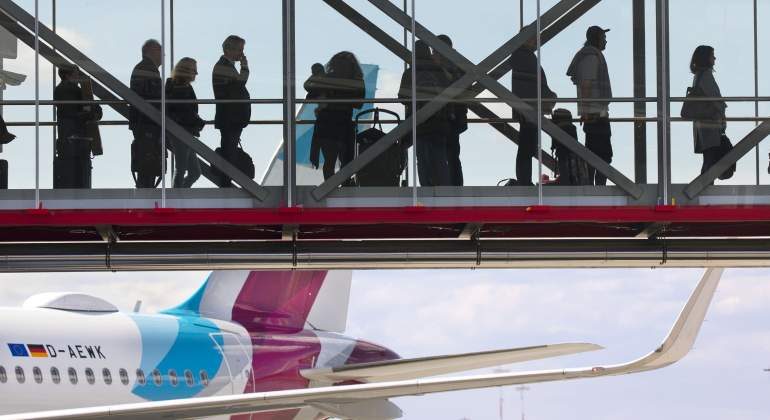 Viajeros cruzan la pasarela de un aeropuerto