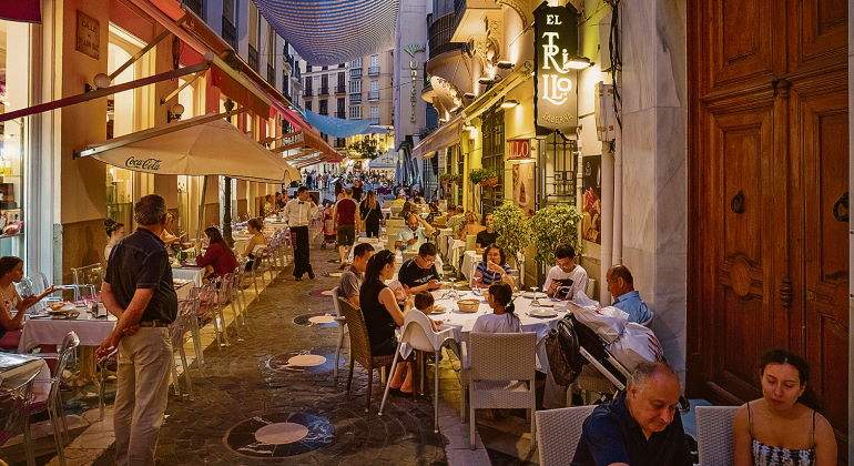 Gente cenando en restaurantes en la noche malaguea