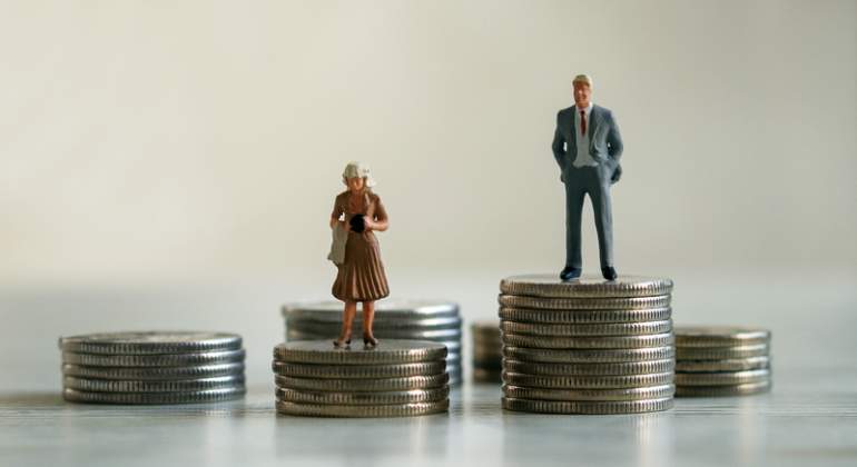 Representacin de la brecha salarial con el mueco de un hombre subido a una montaa de monedas ms alta que su equivalente mujer