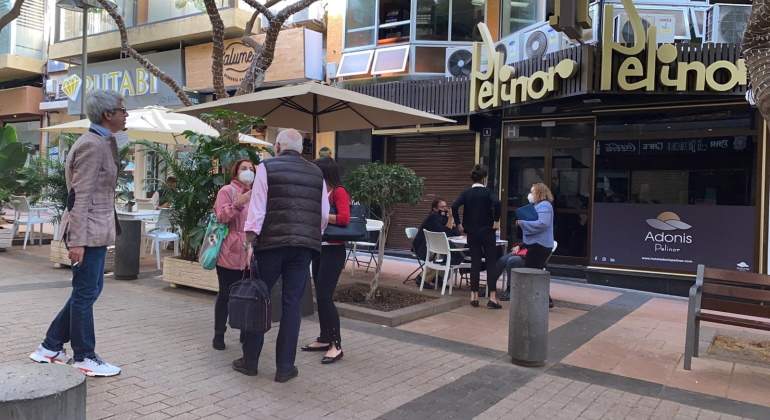 Varias personas en una calle peatonal