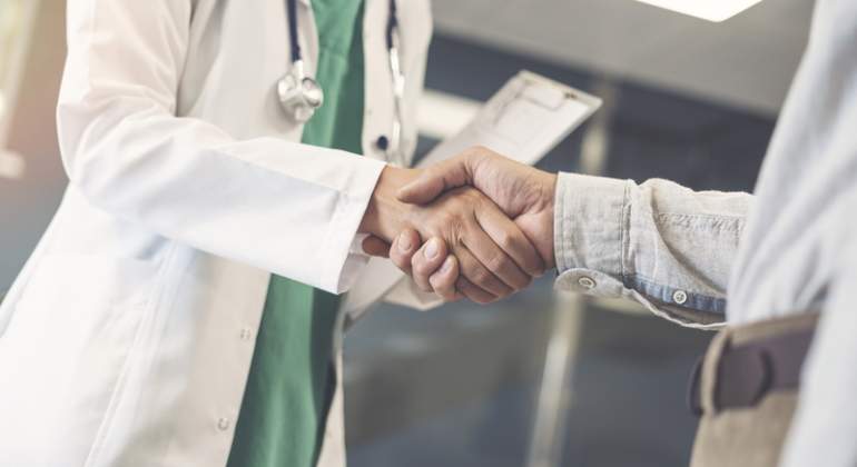 Un mdico da la mano a un paciente