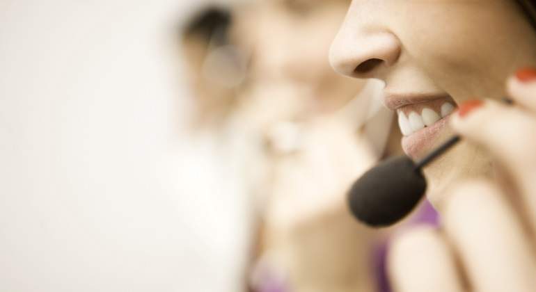 Una-mujer-con-unos-auriculares-con-microfono-iStock.jpg