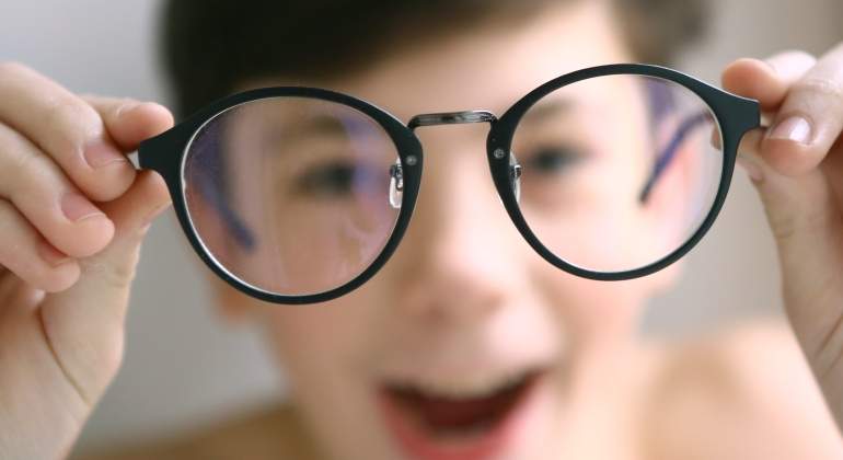 Un nio sonre al ponerse las gafas