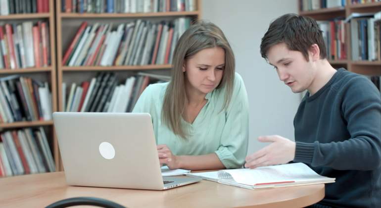 Dos estudiantes trabajan en la biblioteca