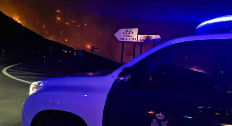 Un coche de la Guardia Civil en Canarias con un incendio al fondo