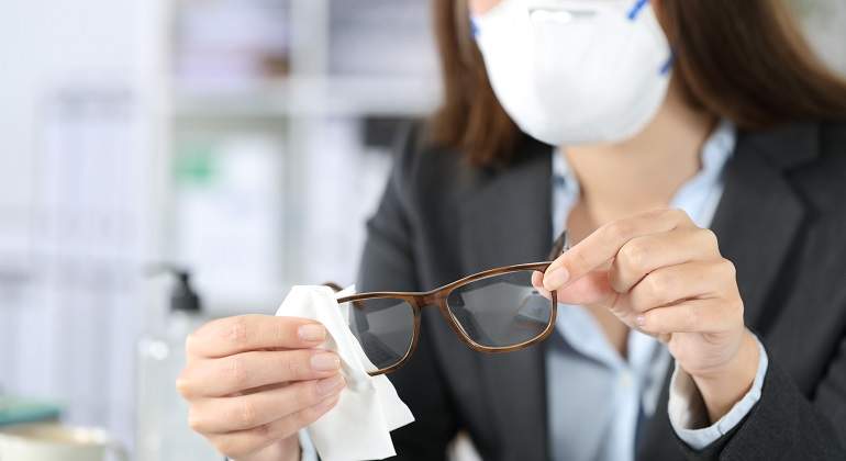 Una-mujer-con-traje-limpiando-sus-gafas-iStock.jpg
