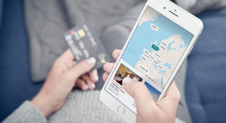 Una mujer usa Airbnb con su iPhone