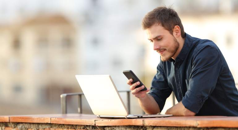 hombre-comprueba-portatil-movil-aire-libre-dreamstime.jpg
