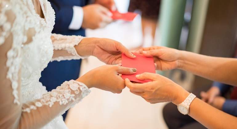 Una-persona-recibiendo-un--sobre-rojo-durante-su-boda-iStock.jpg