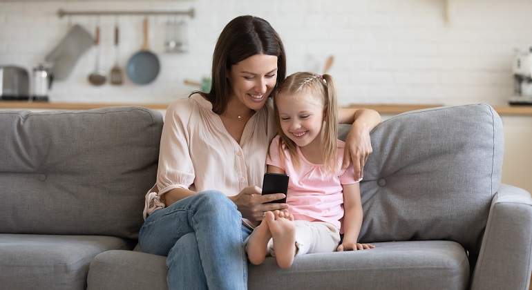 Una-madre-con-su-hija-mirando-el-movil-sentadas-en-el-sofa-iStock.jpg