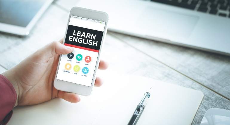 Una persona sostiene un mvil con el mensaje Learn English en la pantalla
