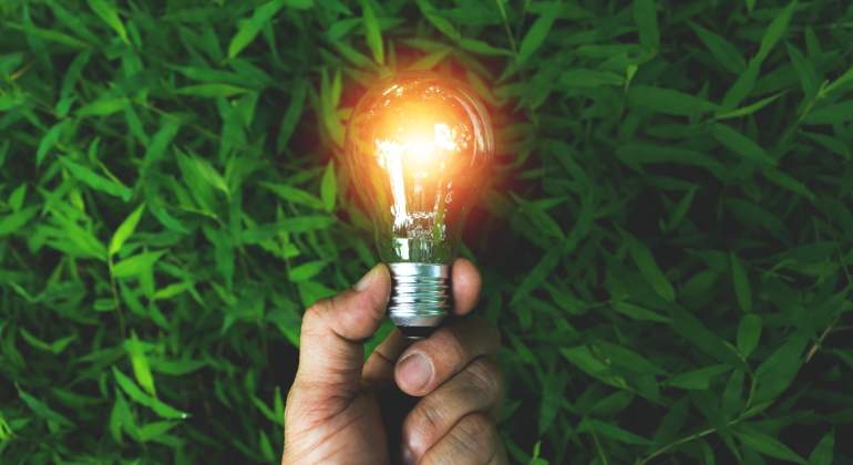 Una mano sostiene una bombilla que simboliza la energa solar renovable limpia