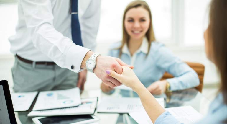 Un gerente da la mano a un cliente o un empleado
