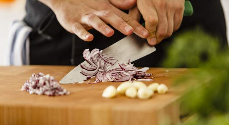 Una-persona-cortando-sobre-una-tabla-cebolla-morada-iStock.jpg