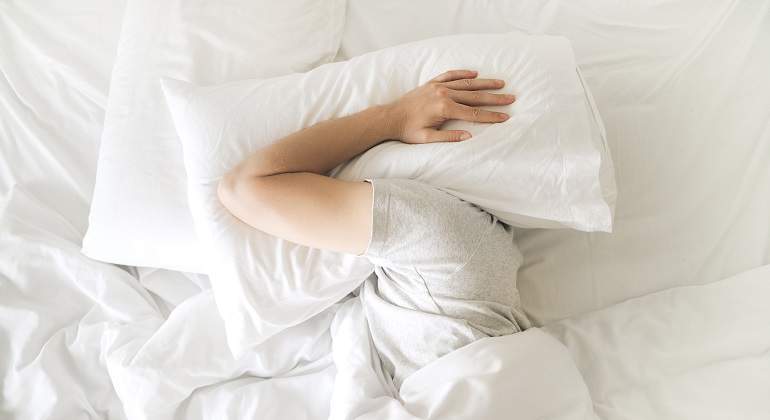 Una-persona-escondiendo-su-cabeza-con-una-almohada-iStock.jpg